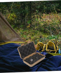 Open case from Three-Piece Survival Storage Case Set for Outdoor Junkies Ultra-Tough Shockproof, beside camping tent in forest