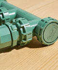 Close-up of Heavy Duty 3 Valve Preassembled Irrigation Manifold with swivel unions, showing watertight seals on a wooden surface.