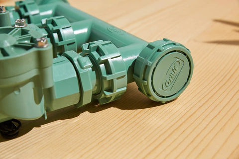 Close-up of Heavy Duty 3 Valve Preassembled Irrigation Manifold with swivel unions, showing watertight seals on a wooden surface.