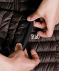 Applying Tenacious Tape Repair Patches Peel And Stick Nylon Gear Patches to a black nylon jacket showing hands holding a black patch.