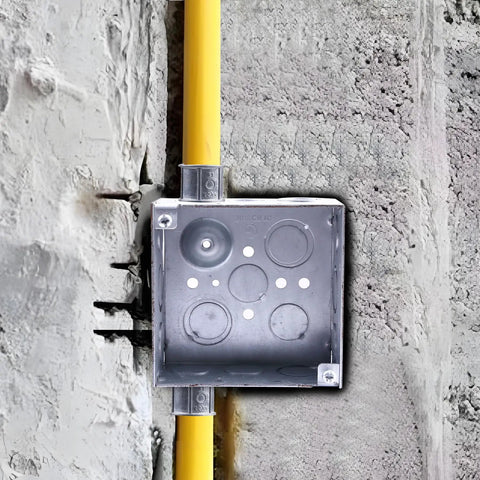 Square Metal Electrical Junction Box 4x4 Inches Two One Eighth Inches Deep Galvanized Steel Drawn Construction With Knockouts on a concrete wall