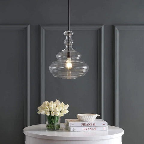 Oil Rubbed Bronze Modern LED Pendant Light With Clear Glass Shade Adjustable Hanging Ceiling Fixture above table with books and flowers.