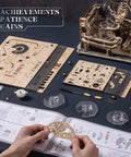 Person assembling the Dope 3D Puzzle Marble Run Kit For Adults Electric Spaceport LGC01 with 472 wooden pieces, instructions visible.