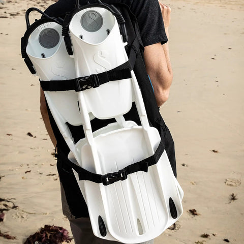 Person carrying Hydros Carry Bag For Scuba Gear With Padded Harness, Top Handle, And Exterior Fin Straps on beach