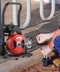 Heavy Duty Electric Sewer Auger Tough As Nails Walk Along Drain Cleaner with auto feed cable in use on clogged drain.