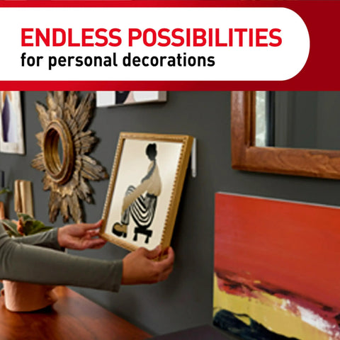 Person using Damage Free Hanging Variety Pack With Ten Pairs Of Picture Hanging Strips to hang art on gray wall.