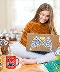 Premium printable vinyl sticker paper pack with green packaging on desk; laptop features angel-wing sticker.