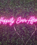 Pink Happily Ever After Neon Sign Wall Art Hangin Neon Light For Party Vibes Wedding Hashtag Decor Kid Bedroom Bar Home 12V DC Power Adapter Included For Easy Setup displayed on leafy background