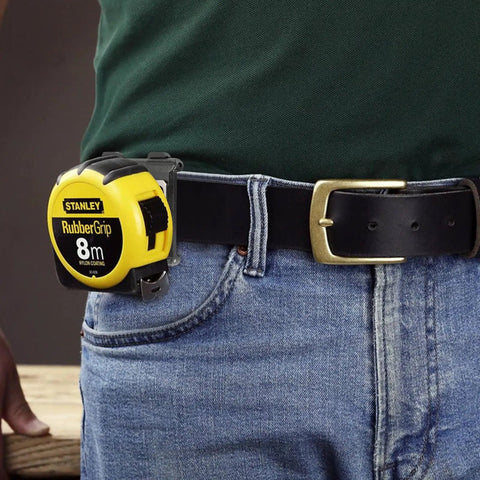 Person wearing jeans with tape measure clipped to belt using Sturdy Tape Measure Holder And Drill Holster With Belt Clip Hands Free Tool Pouch For Measuring Tapes Impact Drivers And Any Hooked Tool Heavy Duty ABS Construction With Reinforced Stainless Steel Clip.