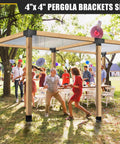 Outdoor gathering under a pergola using the 4x4 Woodworks Pergola Brackets Kit, 3-way corner extension, black powder coated steel, 3.5x3.5 inch