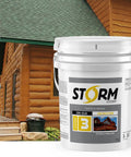 Legit Semi Solid Exterior Wood Stain And Weather Resistant Topcoat In Deep Butternut Tones Easy Brush Application Five Gallon Tub next to wooden deck and log cabin.