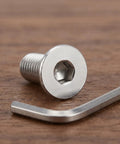 10 Piece Stainless Steel M8x60mm Full Thread Flat Head Screws With Hex Socket on a wooden surface