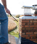 Person applying Heavy Duty Siloxane Chimney Brick Sealer on chimney to protect vertical masonry from moisture damage.