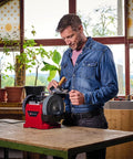 Man using Built Tough Electric Wet Bench Grinder With High Speed Grinding Stone And Leather Honing Wheel for knife sharpening.