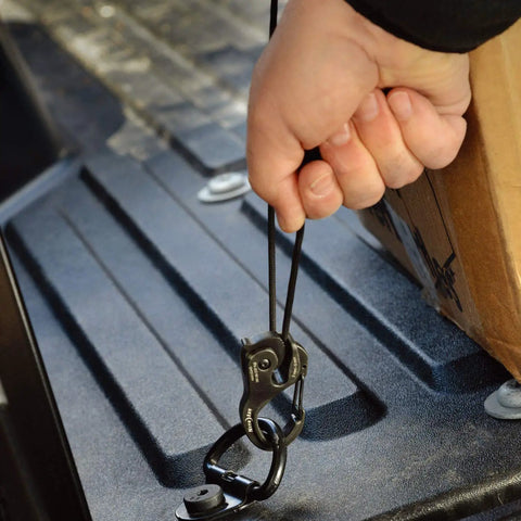 Person using Cam Jam Aluminum XT Paracord Cord Lock With Coyote Color Small Size Durable Aluminum Quick Tie Rope Fastener Includes 10 Ft Coyote Paracord For Easy Pull Through Main Body on truck bed for securing cargo