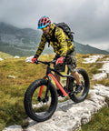 Cyclist on mountain path with grippy fat tire front and rear wheel set for snow beach and e-bike, disc brake wheelset visible