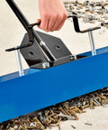 Heavy Duty Magnetic Floor Sweeper With Thirty Six Inch Wide Cleaning Path and Smooth As Butter Rubber Wheels maneuvering over metal debris.