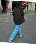 Person walking with Premium Drum Pad Storage Bag Featuring Slick Waterproof Fabric Cover And Smart Mesh Accessory Organizer Pouch For Snare Stand Gear Gig Ready Hella Durable Travel Case.