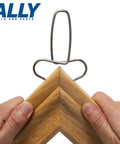 Hands using 12 Piece Pro Grade Miter Clamps Set With Carabiner Clip for securing a miter joint in wood trim.