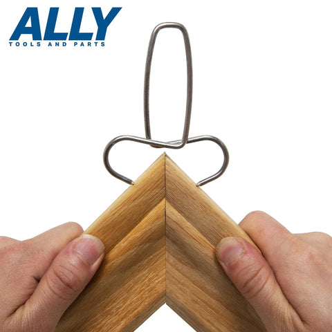 Hands using 12 Piece Pro Grade Miter Clamps Set With Carabiner Clip for securing a miter joint in wood trim.