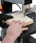 Badass Heavy Duty Steel Benchtop Band Saw With 2.2 Amp Motor cutting plywood with hand positioned on wood.