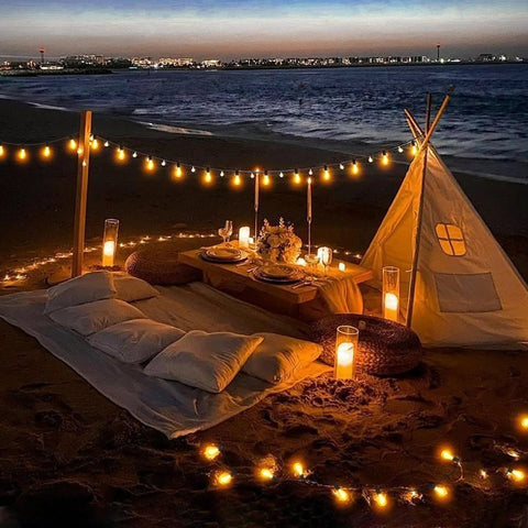 Beach evening setting with 60 Ft Solar String Lights With Remote Control Waterproof Copper Wire Led Bulbs 15 Plus 2 Shatterproof Outdoor