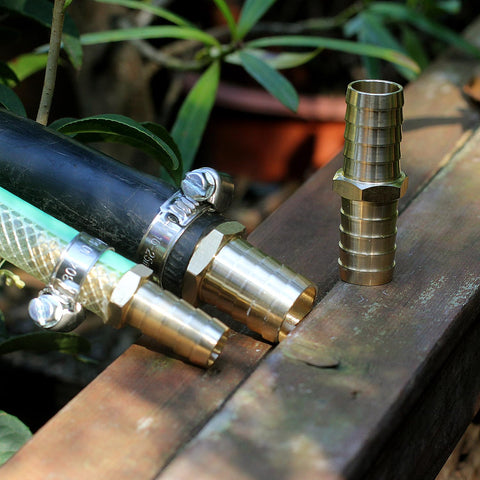 Solid Brass Garden Hose Repair Connector Kit with Half Inch Barb Fittings Dual Head Hose Repair Couplers Includes Stainless Steel Clamps Reusable 2 Pack for Lawn and Yard Watering Easy DIY Fix showing connectors and hose on a wooden surface.