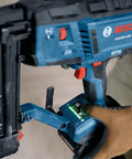 Gutsy 18 Volt Brushless Cordless Brad Nailer Kicks Out 2,000 Nails Per Charge With One Thumb Safety Trigger, showing hand on grip.