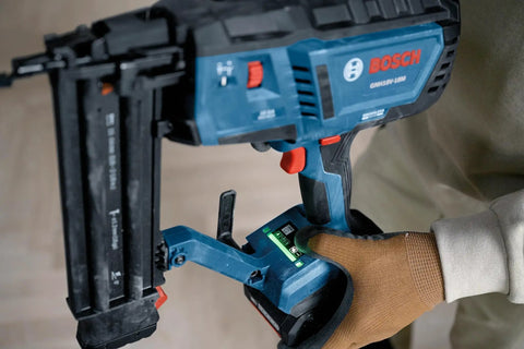 Gutsy 18 Volt Brushless Cordless Brad Nailer Kicks Out 2,000 Nails Per Charge With One Thumb Safety Trigger, showing hand on grip.