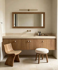 Modern bathroom with wooden cabinet, round mirror, and natural stone countertop showcasing elegance and functionality.