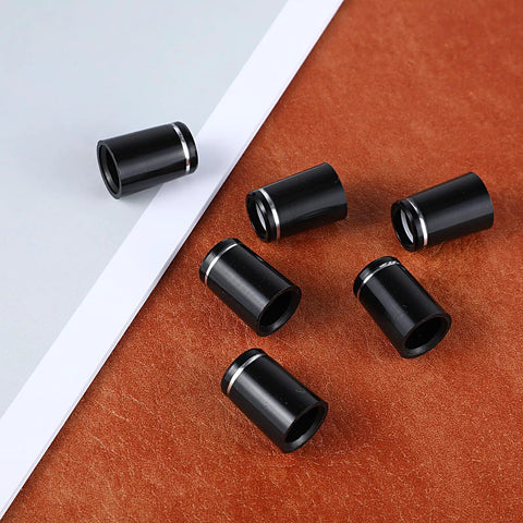 10 Pack.370 Golf Iron Ferrules With Black Body And Silver Ring scattered on a brown surface, highlighting tapered tip design.