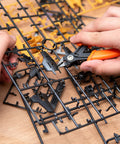 Hands using clippers from 9 Piece Model Tools Kit For Car Model Building And Repairing with plastic model parts