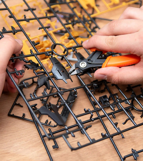 Hands using clippers from 9 Piece Model Tools Kit For Car Model Building And Repairing with plastic model parts