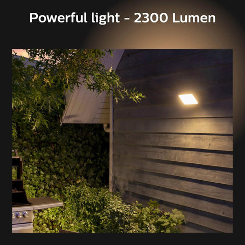 Discover Outdoor Smart Flood Light Fixture Black 15W lit on a wooden wall, showcasing powerful light - 2300 Lumen.