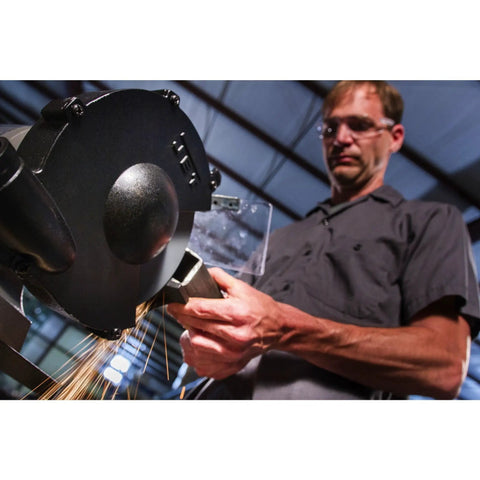 Man using Shop Ready Six Inch Bench Grinder Powered By A Half Horsepower Motor Spinning 3450 RPM Built Different With Heavy Cast Iron Frame.