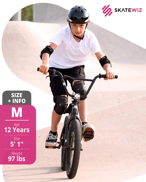 Person wearing knee and elbow pads riding a bicycle at skate park