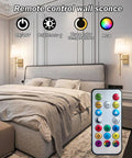 Wireless Battery Operated Wall Sconce Set Of Two With White Fabric Shade Remote Control No Wiring Dimmable Indoor Bedroom Vanity Lighting Bulbs Included Easy Setup Modern Slim Design installed in bedroom with remote control displayed.