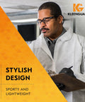 Worker wearing KleenGuard V30 Nemesis Safety Glasses with anti-fog clear lenses and black frame, holding clipboard.