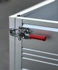 Detail of the aluminum cargo bed latch mechanism on the badass two seater golf cart with bright yellow paint.