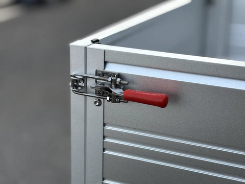 Detail of the aluminum cargo bed latch mechanism on the badass two seater golf cart with bright yellow paint.