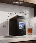 Crystal Clear Ice Ball Maker for Countertop 2.4 Inch Spheres mini size next to decanter on kitchen counter