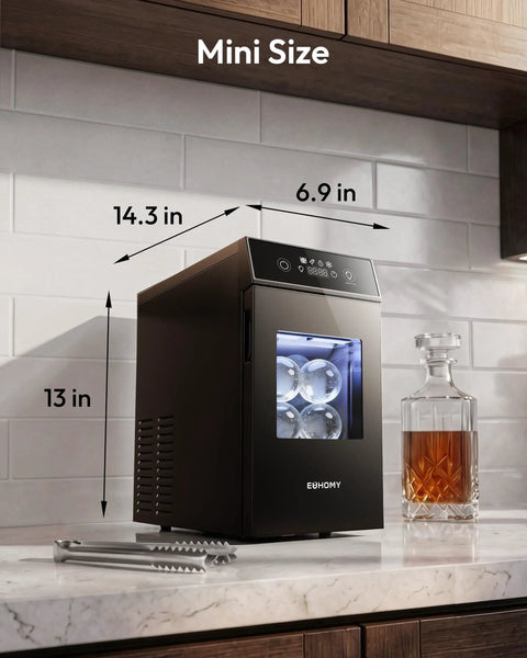 Crystal Clear Ice Ball Maker for Countertop 2.4 Inch Spheres mini size next to decanter on kitchen counter