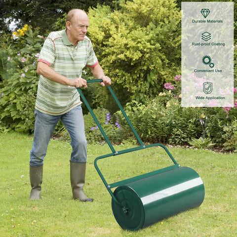 Man uses 24 Inch Tow Behind Lawn Roller With 13 Gallon Water Or Sand Fill U Shaped Handle Easy Push Or Pull Setup for seed bedding in garden.