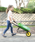 Child using Officially Licensed Kids Wheelbarrow For Backyard Projects 34 Inch Steel Wheelbarrow with Vinyl Grips outdoors