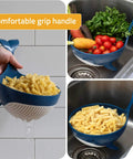 Pastail Medium Whale Shaped Pasta Colander for draining pasta and vegetables, stands on fins, in use over sink, showing comfortable grip handle