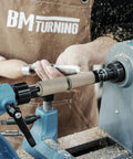 Woodworker using Pen Mandrel Bundle For Woodturning Lathe With Mandrel Saver, 2MT Taper, crafting a pen at a lathe machine.