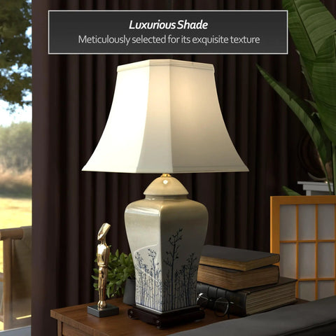 Blue And White Spring Forest Porcelain Vase Lamp Hand Crafted Chinese Porcelain With Hand Painted Winter Trees And Birds Includes Fabric Shade And Built In Wooden Base Delivers Classic Vintage Vibe And Uses A 100 Watt 3 Way Bulb on wooden nightstand in living room.