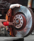 Mechanic installing Heavy Duty 4 Pack 1.98 Inch Grey Rubber Bearing Dust Caps on trailer wheel hub, close-up view.