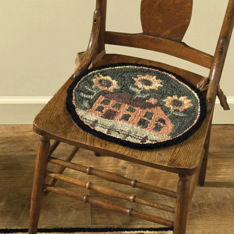 Round Chair Pad Featuring House And Sunflowers Folk Art Design on a wooden chair, showcasing 14.5 inch plush poly loop yarn.