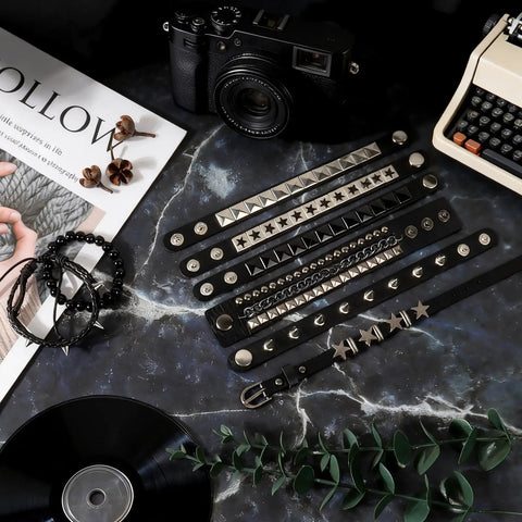 Dope Eight Piece Punk Rock Studded Leather Bracelet Set With Adjustable Spiked Zinc Cuffs for that raw 80s concert vibe displayed on a dark surface.